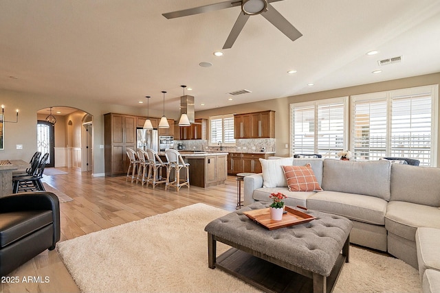 living room featuring ceiling fan and light hardwood / wood-style flooring