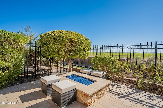 view of patio with an outdoor fire pit, a beach view, and a water view