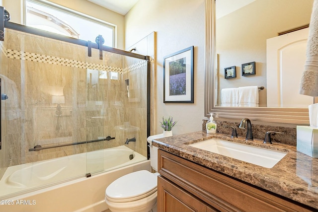 full bathroom featuring enclosed tub / shower combo, vanity, and toilet