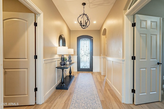 entryway with an inviting chandelier and light wood-type flooring