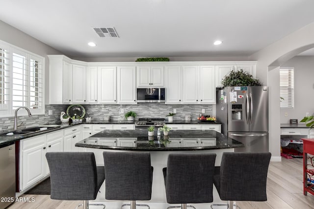 kitchen with visible vents, appliances with stainless steel finishes, white cabinetry, and a sink