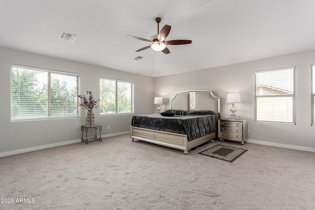 carpeted bedroom with baseboards, a ceiling fan, and visible vents
