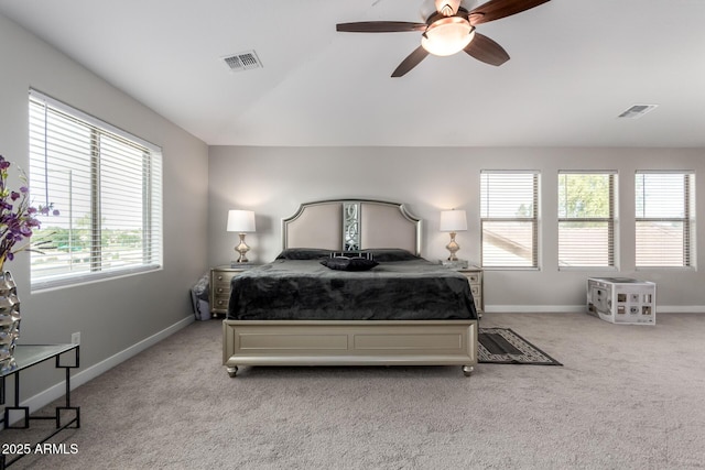 carpeted bedroom with baseboards, vaulted ceiling, visible vents, and a ceiling fan