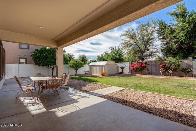 view of patio featuring a fenced backyard, an outdoor structure, a storage shed, and outdoor dining space