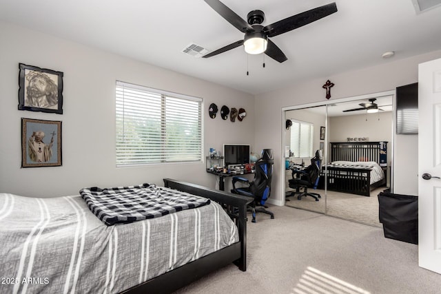 carpeted bedroom featuring a closet, visible vents, and multiple windows