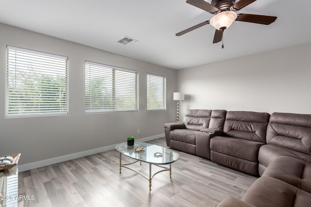 living area featuring ceiling fan, baseboards, visible vents, and light wood-style flooring