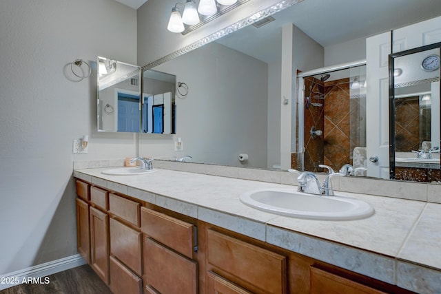 bathroom with walk in shower, vanity, and hardwood / wood-style flooring