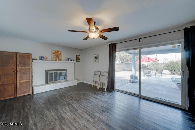 unfurnished living room with ceiling fan, a fireplace, and dark hardwood / wood-style flooring