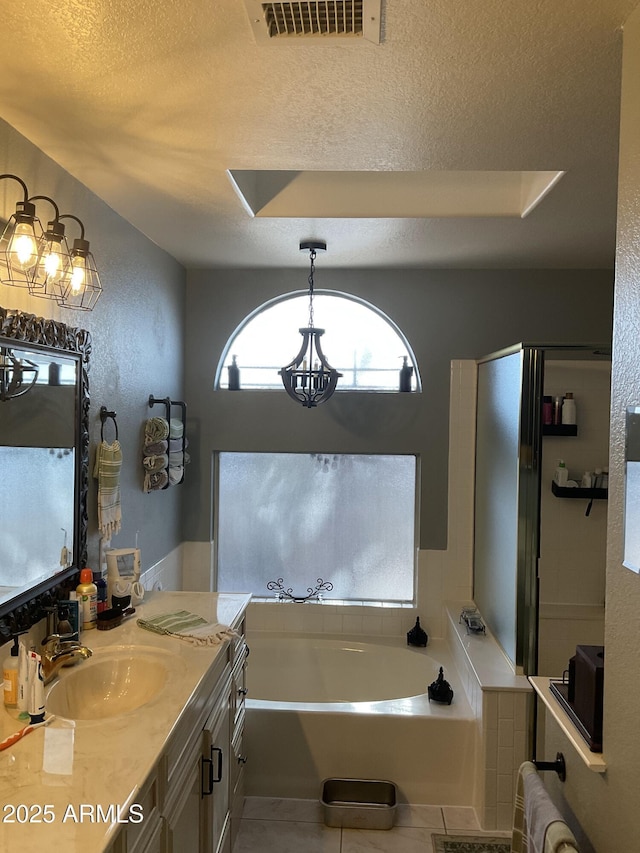 bathroom featuring vanity, a tray ceiling, a textured ceiling, tile patterned floors, and shower with separate bathtub