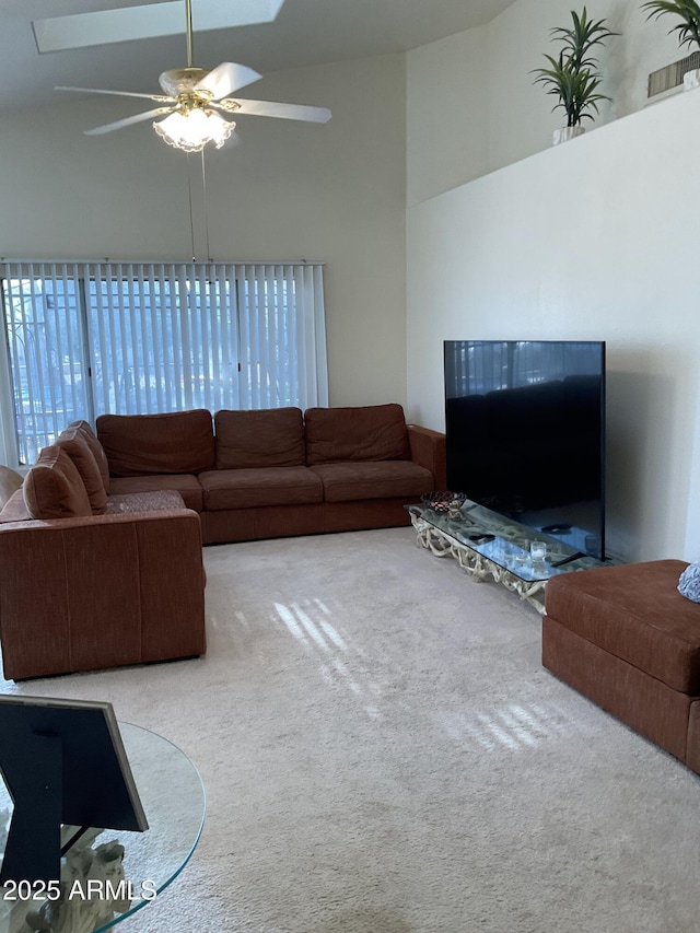 living room featuring light carpet, ceiling fan, and a high ceiling