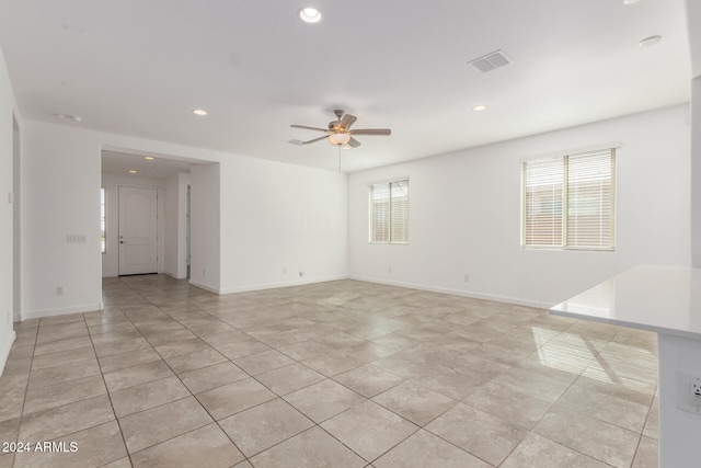 tiled spare room with ceiling fan