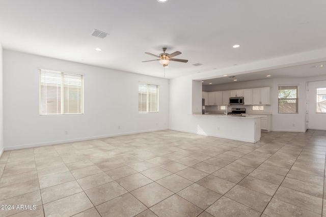 unfurnished living room with light tile patterned flooring and ceiling fan