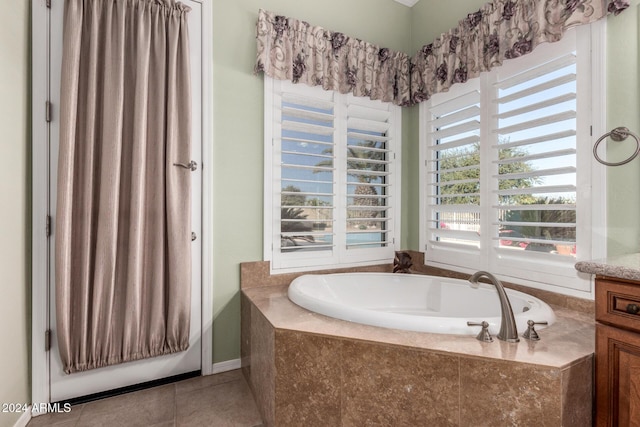 bathroom featuring tile patterned floors, tiled tub, and vanity