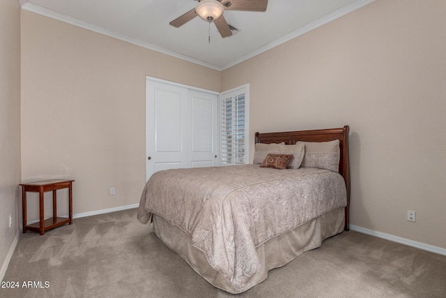 carpeted bedroom with a closet, ceiling fan, and ornamental molding