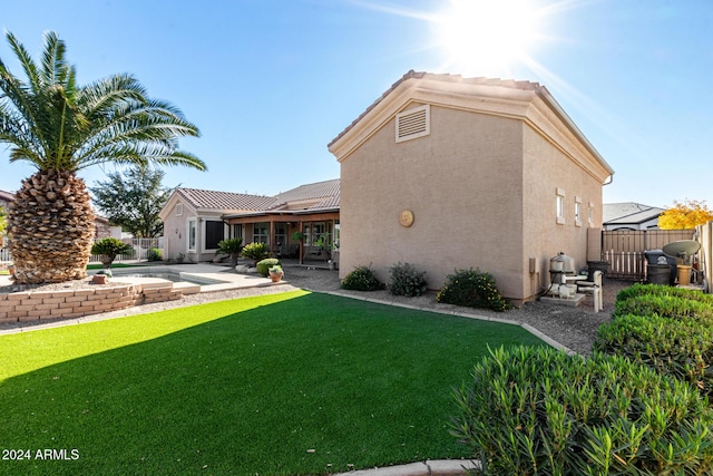 back of house with a patio, a fenced in pool, and a lawn