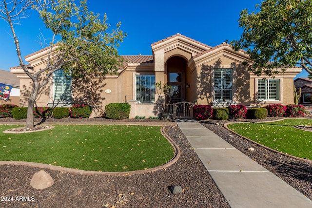 mediterranean / spanish house featuring a front yard