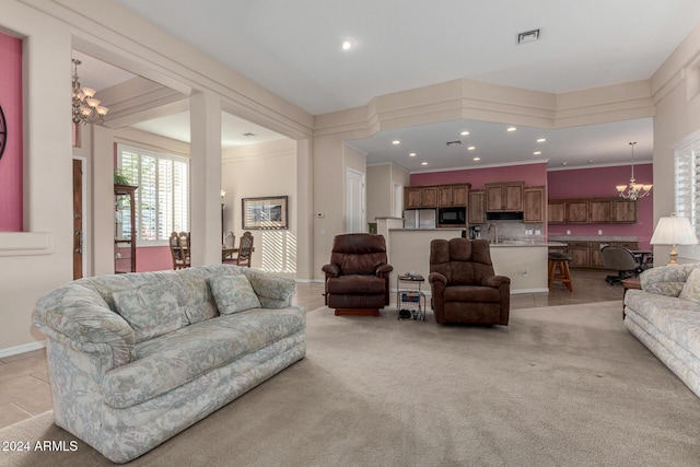 living room featuring a chandelier, light carpet, and ornamental molding