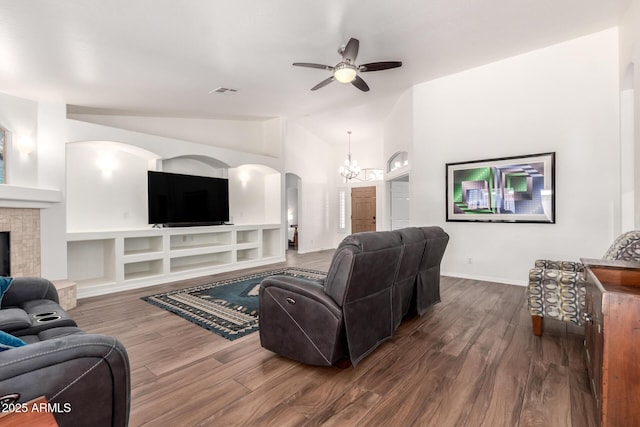 living room with arched walkways, visible vents, dark wood-type flooring, vaulted ceiling, and a tile fireplace