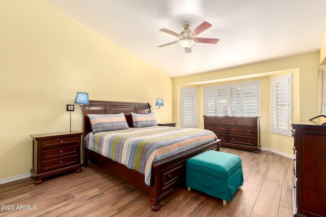 bedroom with lofted ceiling, wood finished floors, a ceiling fan, and baseboards