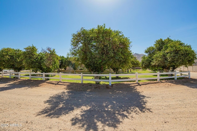 view of community featuring fence, a mountain view, and a rural view