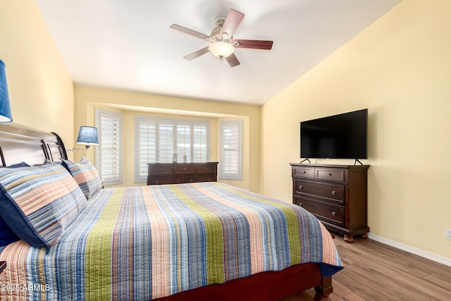 bedroom featuring vaulted ceiling, ceiling fan, wood finished floors, and baseboards