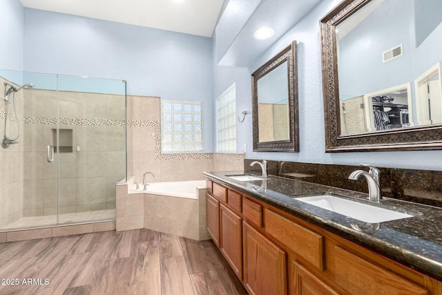 bathroom with a bath, a shower stall, visible vents, and a sink