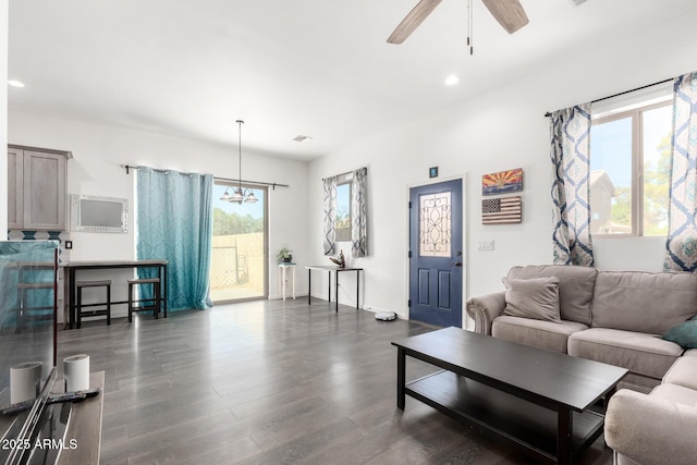 living area featuring ceiling fan with notable chandelier, dark wood finished floors, visible vents, and recessed lighting