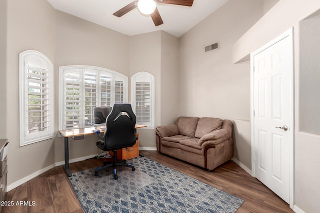 office area featuring visible vents, a ceiling fan, vaulted ceiling, wood finished floors, and baseboards