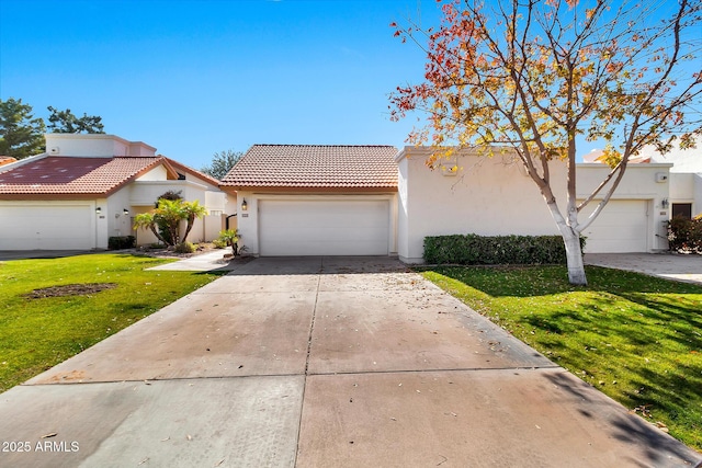 mediterranean / spanish house with a garage and a front lawn