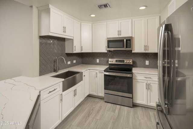 16 W Encanto Blvd Unit 22, Phoenix, AZ 85003 - kitchen featuring appliances with stainless steel finishes, a sink, white cabinets, backsplash, and recessed lighting