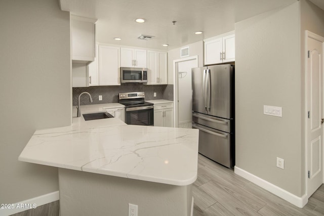 16 W Encanto Blvd Unit 22, Phoenix, AZ 85003 - kitchen featuring appliances with stainless steel finishes, a sink, a peninsula, baseboards, and recessed lighting