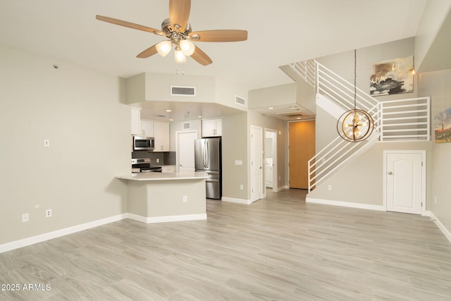 16 W Encanto Blvd Unit 22, Phoenix, AZ 85003 - unfurnished living room featuring stairs, a ceiling fan, baseboards, and light wood-style flooring