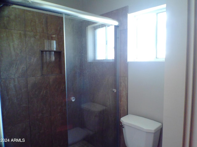 bathroom featuring toilet and an enclosed shower