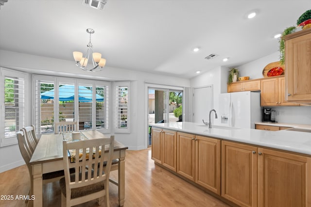 5024 S Citrus Ct, Gilbert, AZ 85298 - kitchen with white refrigerator with ice dispenser, light countertops, a chandelier, light wood-style floors, and a peninsula