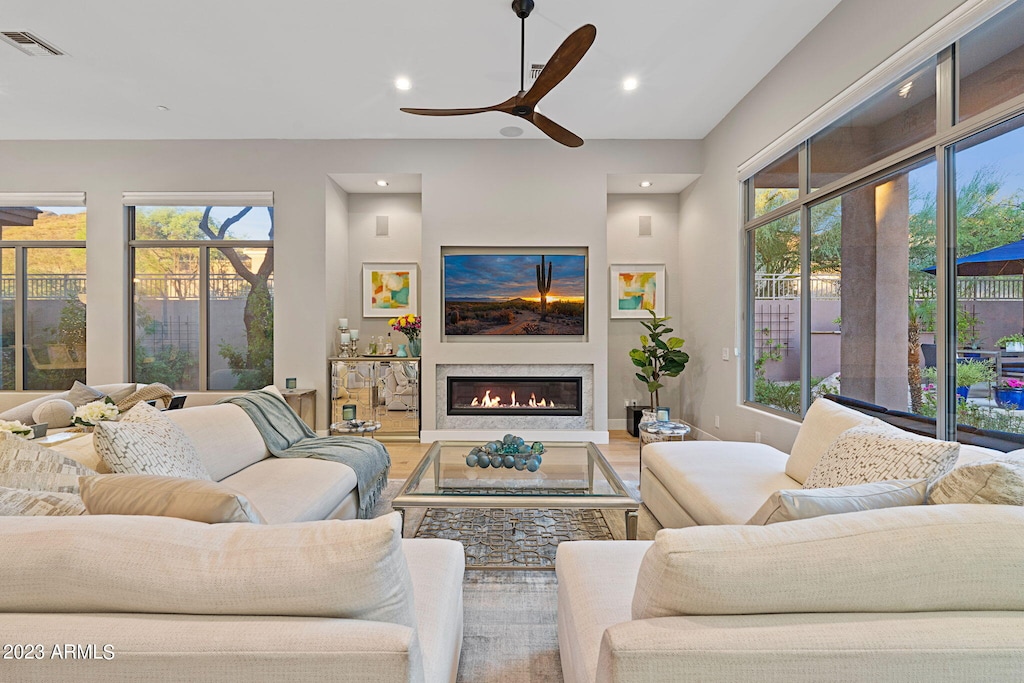 living room with plenty of natural light, a glass covered fireplace, and visible vents