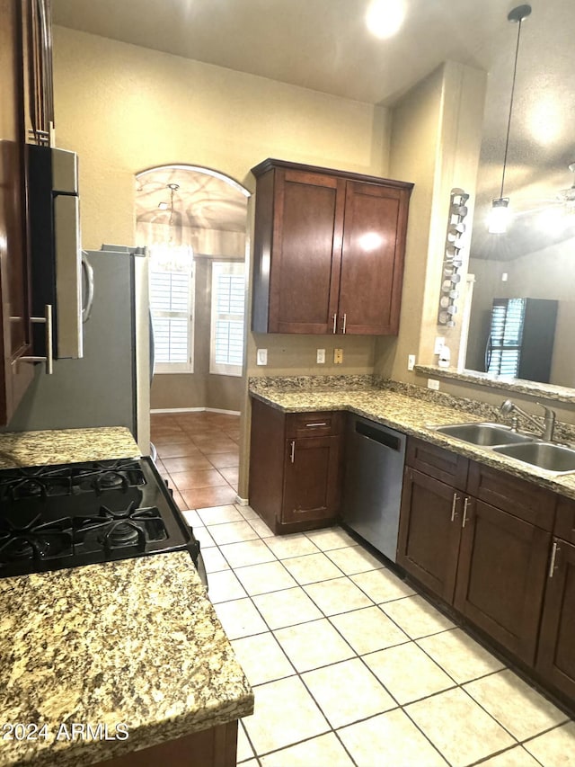 kitchen featuring light stone counters, gas range oven, sink, dishwasher, and light tile patterned flooring