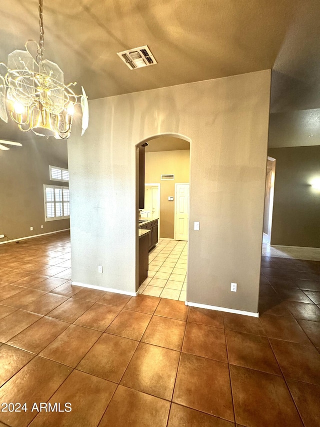 unfurnished dining area with tile patterned floors and a notable chandelier