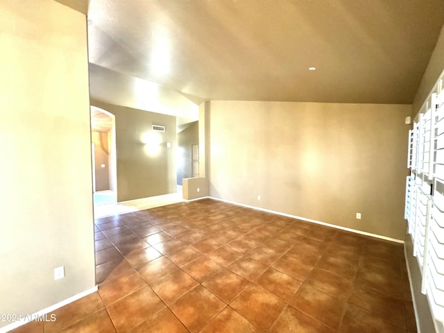 empty room featuring vaulted ceiling