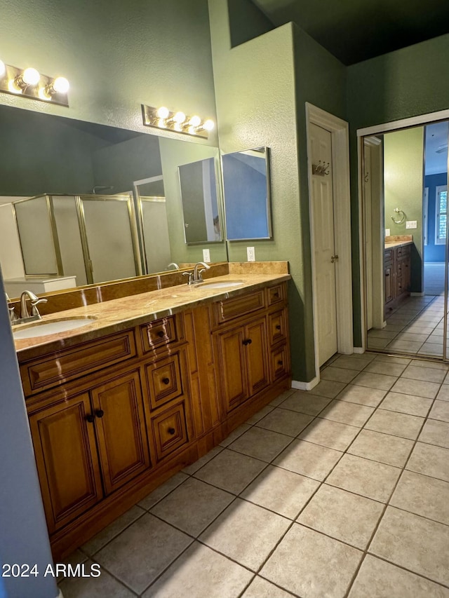 bathroom with tile patterned flooring, vanity, and a shower with door