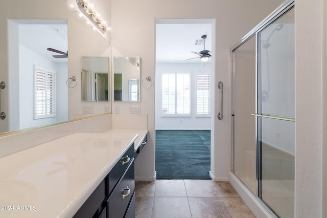 bathroom with ceiling fan, vanity, a shower with shower door, and tile patterned flooring