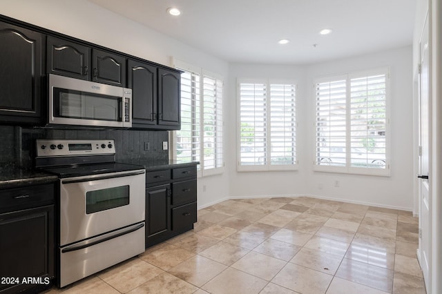 kitchen featuring stainless steel appliances, backsplash, and light tile patterned floors