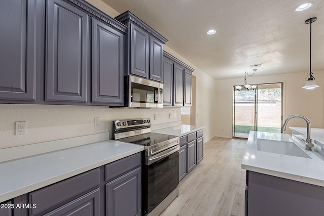 kitchen with sink, an inviting chandelier, decorative light fixtures, light hardwood / wood-style flooring, and stainless steel appliances