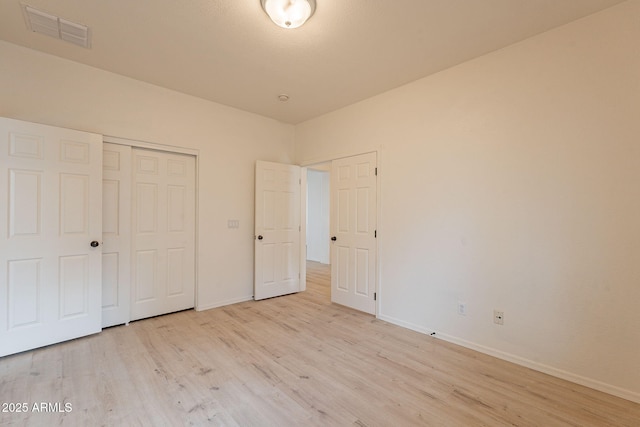 unfurnished bedroom with light hardwood / wood-style flooring and a closet