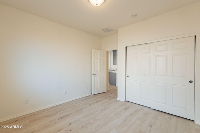 unfurnished bedroom featuring a closet and light wood-type flooring