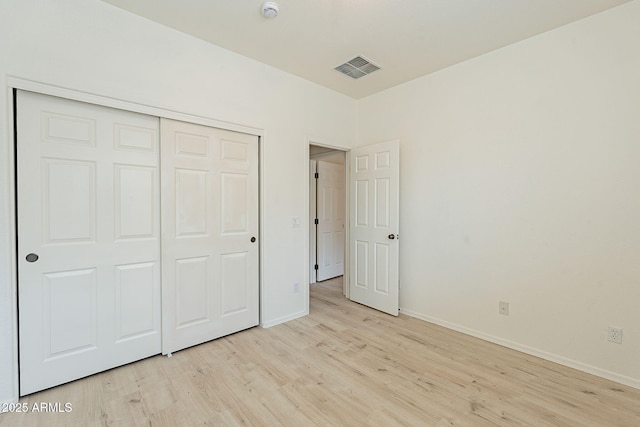 unfurnished bedroom featuring light hardwood / wood-style floors and a closet