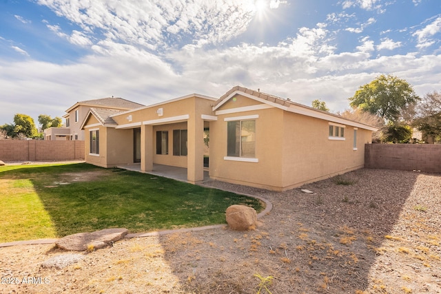 back of property featuring a lawn and a patio