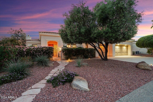 view of front of house with a garage and cooling unit