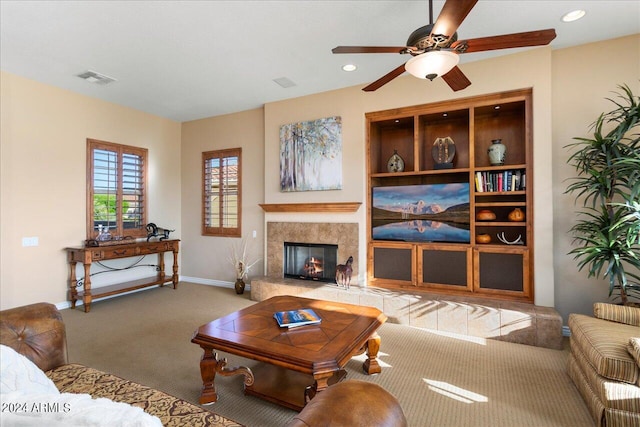 living room with a fireplace, ceiling fan, and carpet flooring