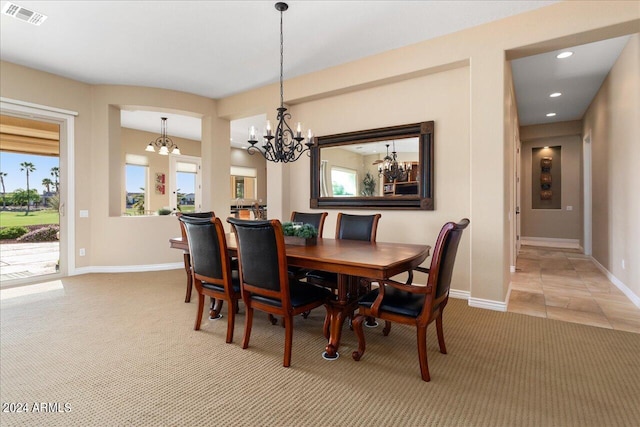 dining room with carpet flooring and an inviting chandelier