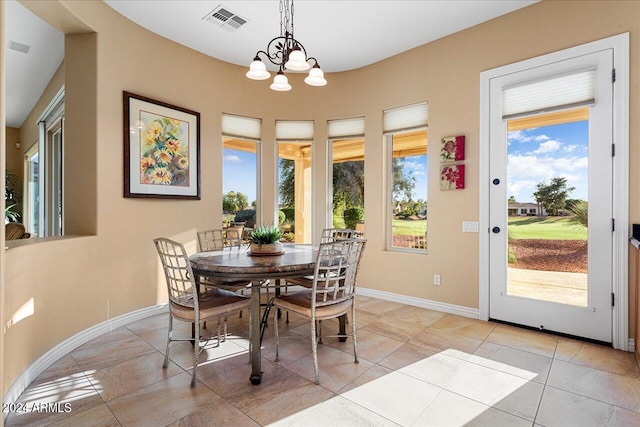 dining area featuring a notable chandelier and light tile patterned flooring